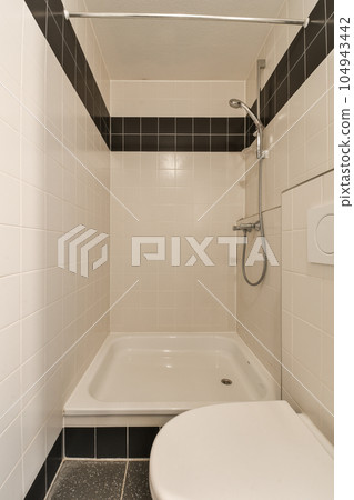 a small bathroom with black and white tiles on the walls, tub, toilet, and shower stall in it 104943442