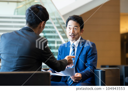Middle-aged businessman having a business meeting 104943553