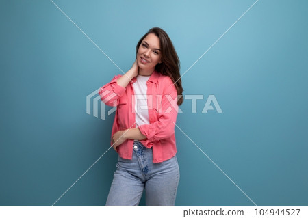portrait of a woman with dark brown hair in jeans and a tank top with a shirt posing in the studio portrait of a woman with dark brown hair in jeans and a tank top with a shirt posing in the studio 104944527
