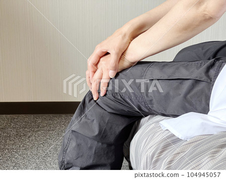 Hand holding the knee with both hands Hand holding the knee with both hands 104945057
