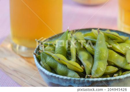 Close-up of green soybeans with beer in the background 104945426
