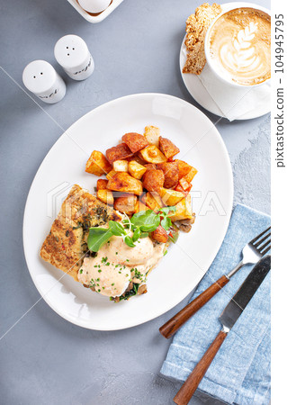 Eggs Benedict with focaccia and potatoes 104945795