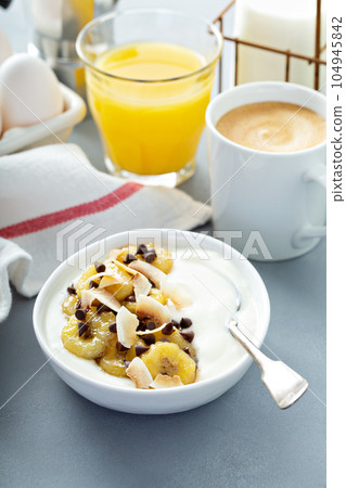 Plain yogurt with bananas, chocolate and coconut Plain yogurt with bananas, chocolate and coconut 104945842