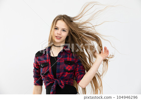 Young girl's long hair flies in the air in the wind 104946296