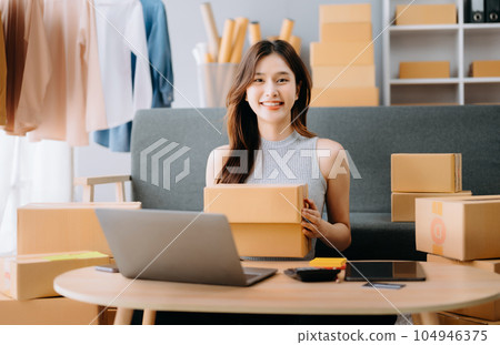 Startup small business SME, Entrepreneur owner woman using smartphone or tablet taking receive and checking online purchase shopping order to preparing pack product box. . Startup small business SME, Entrepreneur owner woman using smartphone or tablet taking receive and checking online purchase shopping order to preparing pack product box. . 104946375