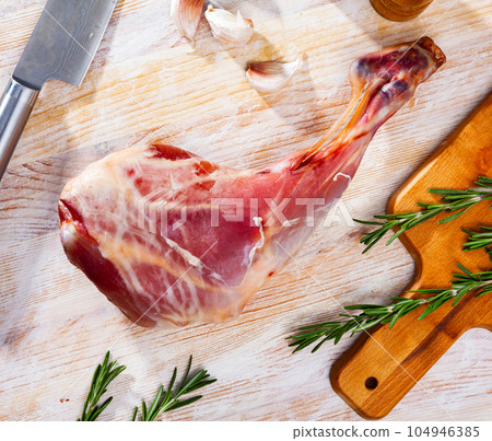 Raw young goat leg with rosemary and spices 104946385
