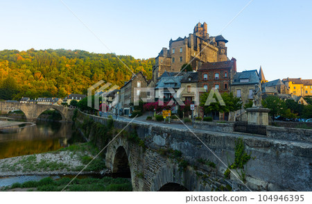 French township of Estaing on bank of Lot River with arched bridge and fortified castle French township of Estaing on bank of Lot River with arched bridge and fortified castle 104946395