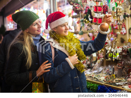 Winter holidays and celebration concept - happy mother and teenager daughter at christmas market closeup Winter holidays and celebration concept - happy mother and teenager daughter at christmas market closeup 104946446