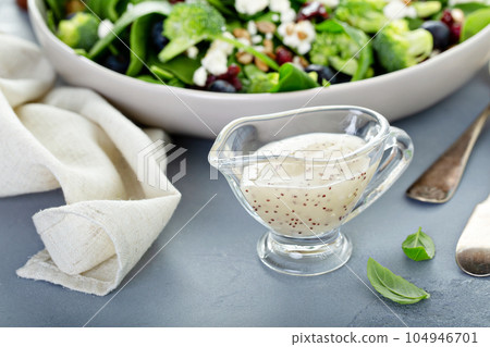 Poppy seed salad dressing in a sauce dish Poppy seed salad dressing in a sauce dish 104946701