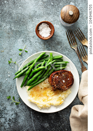 Traditional dinner meal with a bacon wrapped steak and potatoes Traditional dinner meal with a bacon wrapped steak and potatoes 104946705