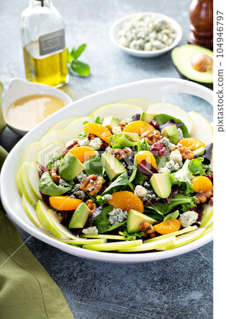 Fresh salad with bleu cheese, walnuts, apples and mandarins 104946797