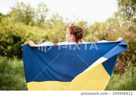 Ukraines Independence Flag Day. Constitution day. Ukrainian child girl in embroidered shirt vyshyvanka with yellow and blue flag of Ukraine in field. flag symbols of Ukraine. Kyiv, Kiev day Ukraines Independence Flag Day. Constitution day. Ukrainian child girl in embroidered shirt vyshyvanka with yellow and blue flag of Ukraine in field. flag symbols of Ukraine. Kyiv, Kiev day 104946912