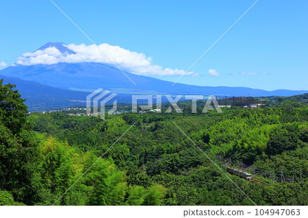 The Tokaido Main Line runs along a mountain road with Mt. Fuji in the background 104947063
