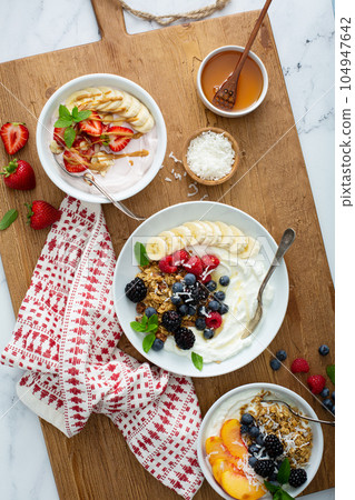 Variety of yogurt bowls with strawberry and plain yogurt 104947642