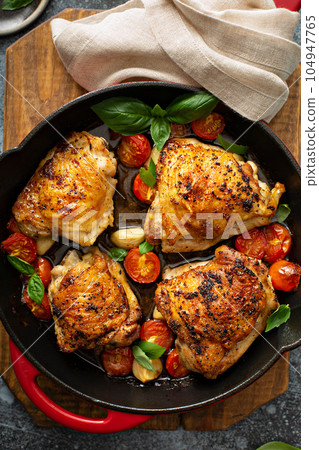 Chicken thighs roasted with tomatoes and garlic Chicken thighs roasted with tomatoes and garlic 104947765