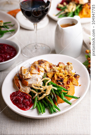 Festive Thankgiving dinner table with plates of food 104947785