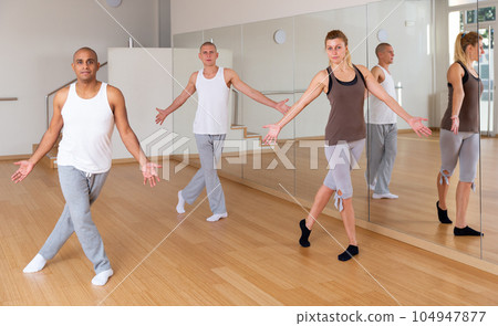 Young adults practicing dance movements in choreography class Young adults practicing dance movements in choreography class 104947877