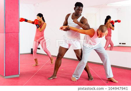 Sparring of two men at self-defense training in sports club Sparring of two men at self-defense training in sports club 104947941