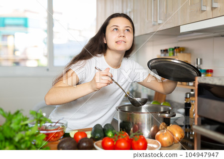 Portrait of confused young woman at kitchen Portrait of confused young woman at kitchen 104947947