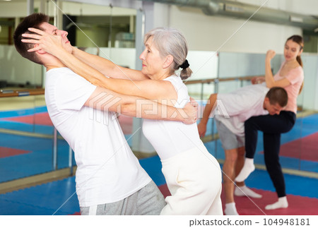 Senior woman performing eye-gouging move during self-defence training Senior woman performing eye-gouging move during self-defence training 104948181