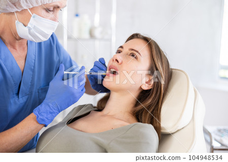 Young woman getting lip fillers. Young woman getting lip fillers. 104948534
