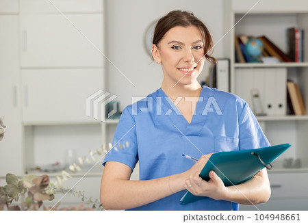 Portrait of positive female doctor with folder Portrait of positive female doctor with folder 104948661