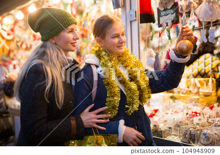 Mother and daughter choosing christmas decorations 104948909