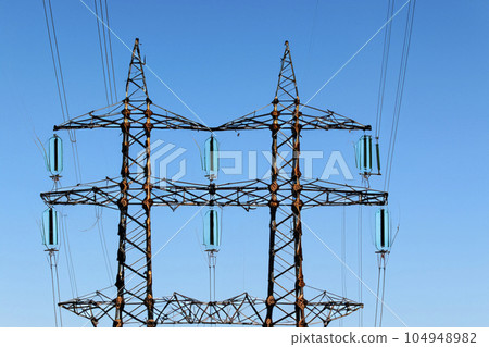 High voltage tower. High voltage. Electricity transmission power lines at sunset (high voltage pylon). High voltage circuit breaker in a power substation. Aerial view of high voltage power lines. 104948982