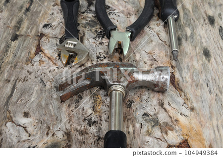 Hammer on wood grain background Hammer on wood grain background 104949384