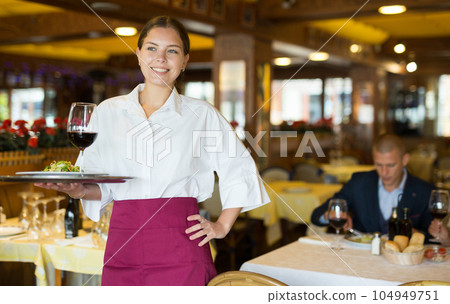 Waiter standing with serving tray, recommending dishes in restaurant Waiter standing with serving tray, recommending dishes in restaurant 104949751