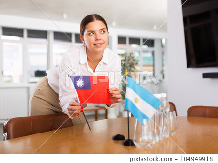 Employee of delegation prepares negotiating table - sets up flag of Taiwan and Argentine 104949918