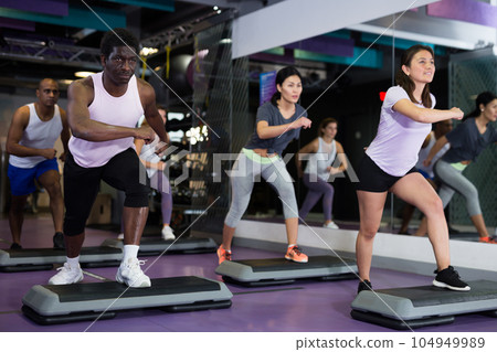 People training on step platforms in gym People training on step platforms in gym 104949989