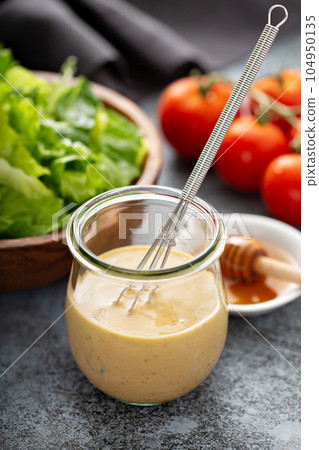 Homemade honey mustard sauce in a glass jar 104950135