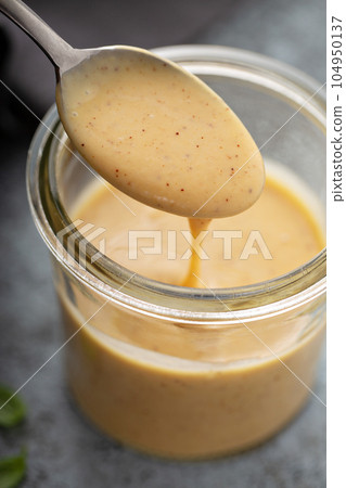 Homemade honey mustard sauce in a glass jar Homemade honey mustard sauce in a glass jar 104950137