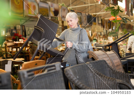 Mature woman choosing chair in furniture store Mature woman choosing chair in furniture store 104950183