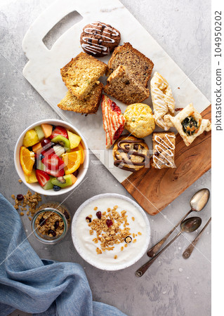 Breakfast table with granola, yogurt and fruit 104950202