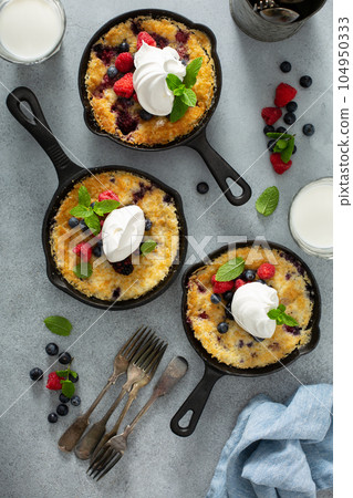 Berry crumble baked in small cast iron pans 104950333