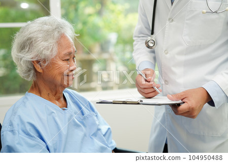 Doctor help Asian elderly woman disability patient sitting on wheelchair in hospital, medical concept. Doctor help Asian elderly woman disability patient sitting on wheelchair in hospital, medical concept. 104950488