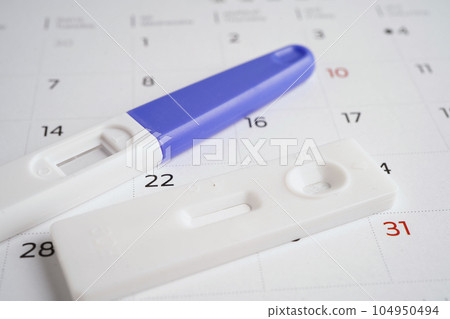 Pregnancy test for female on calendar, ovulation day. 104950494