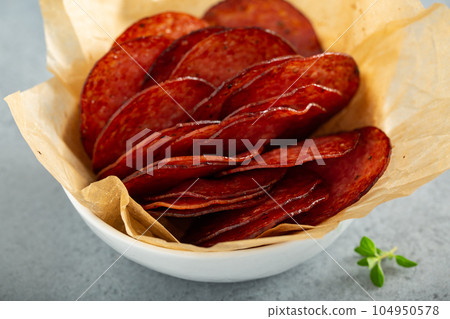 Salami chips baked in the oven with cheese sauces 104950578
