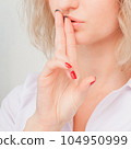 keeps fingers on lips, demonstrates silence sign, has a secret. 104950999