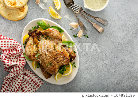 Whole lemon herbs and garlic roasted chicken 104951189