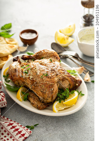 Whole lemon herbs and garlic roasted chicken Whole lemon herbs and garlic roasted chicken 104951196