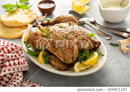 Whole lemon herbs and garlic roasted chicken 104951197