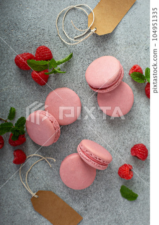 Raspberry macarons on gray table 104951335