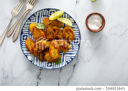 Fried caramelized plantains served with lime wedges Fried caramelized plantains served with lime wedges 104951643