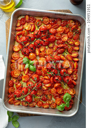 Cherry tomatoes roasted with garlic and spices on a tray Cherry tomatoes roasted with garlic and spices on a tray 104951911