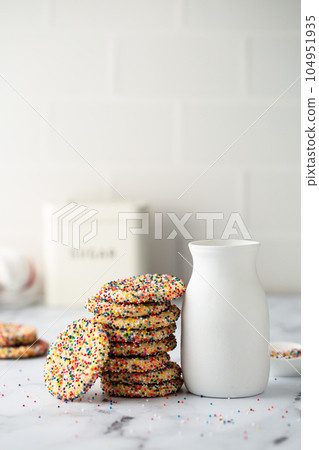 Sugar cookies with sprinkles and a bottle of milk 104951935