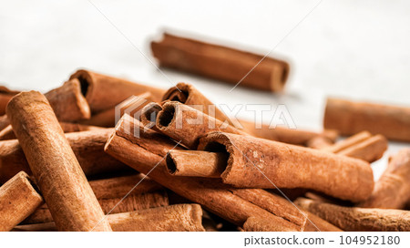 Pile of organic cinnamon bark, selective focus photo - only few sticks in focus 104952180