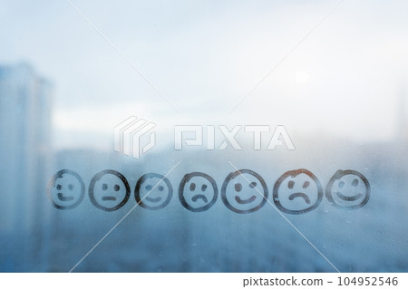 Foggy glass on window with drawn seven smile face with different emotions, concept photo of diversity, communication 104952546